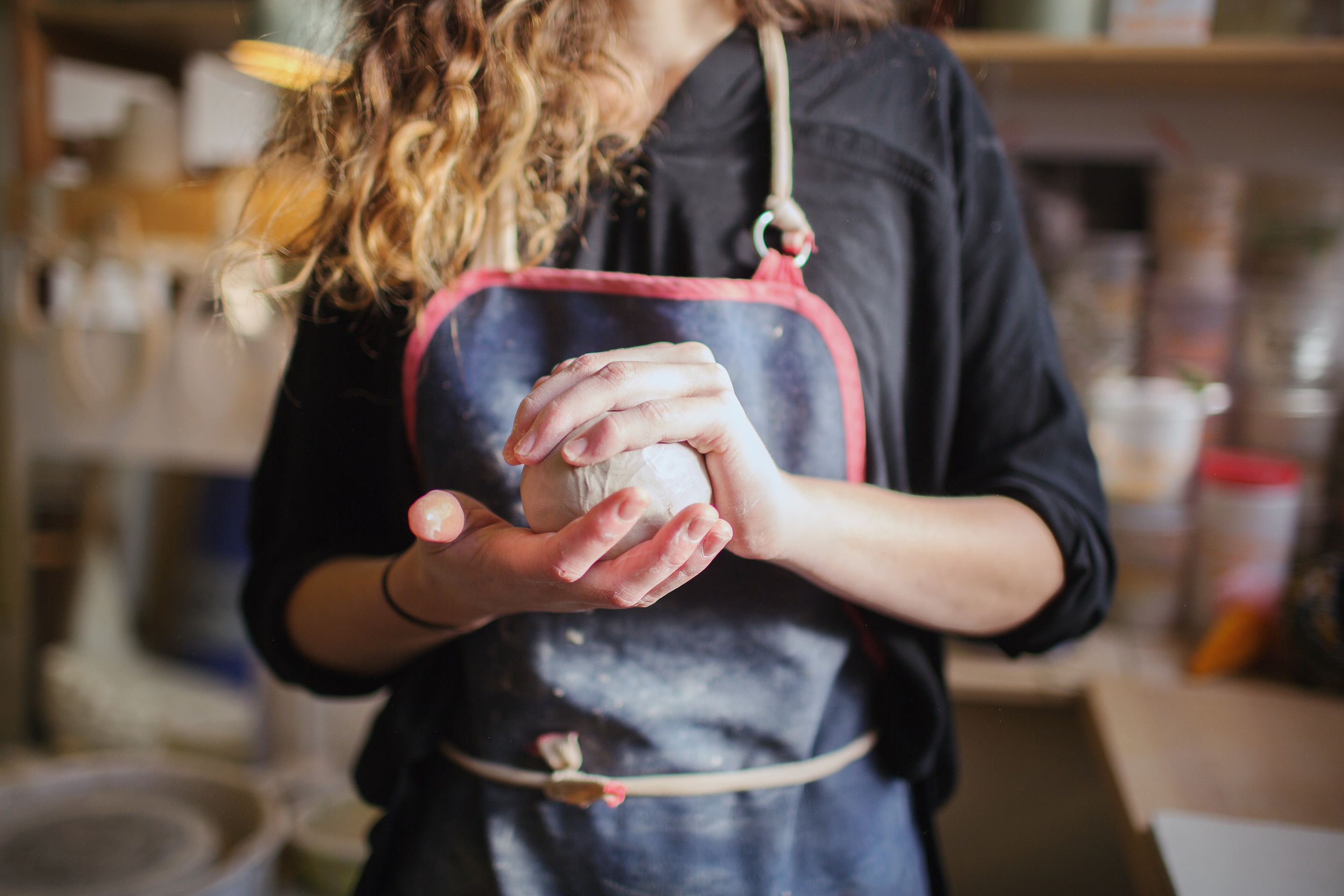 femme tenant une boule d'argile de céramique